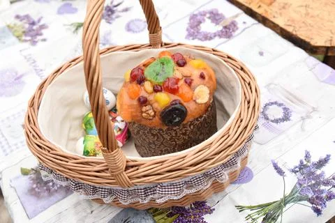 Decorated wicker Easter basket with Easter cake, painted eggs, treat Stock Photos