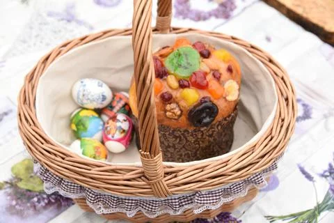 Decorated wicker Easter basket with Easter cake, painted eggs, treat Foto stock