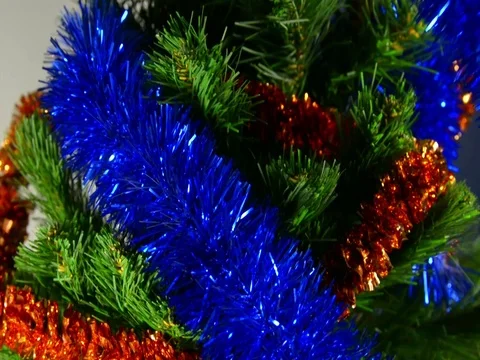 Decorates a Christmas tree. Hangs tinsel on Christmas on a bright Christmas tree Stock Footage 121137302