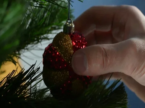 Decorates a Christmas tree. Hangs tinsel on Christmas on a bright Christmas tree Stock Footage 121137356
