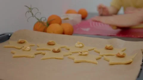 Decorating biscuits with seeds before baking in a cozy kitchen Stock Footage 329281871