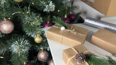 Decorating boxes with Christmas gifts on the background of a fir tree with a Stock Footage 255956947