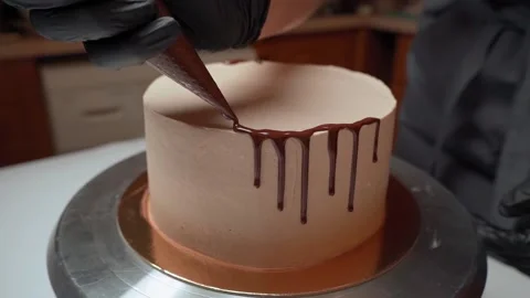 Decorating the cake with chocolate with drops with a pastry bag Stock Footage 153772528