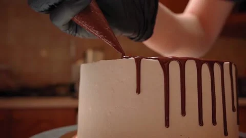 Decorating the cake with chocolate with drops with a pastry bag. Close-up Video stock 160558725