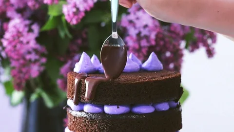 Decorating cake with chocolate liquid coating using spoon. Stock Footage 102042573