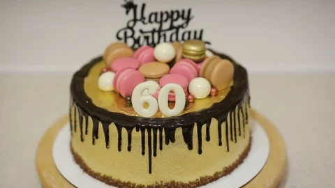 Decorating cake with macaron cookies, candies and white chocolate balls for Stock Footage 102432683