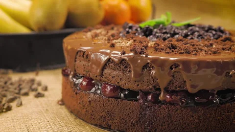 Decorating the chocolate cake on the straw covered table. close up.  Stock Footage 144311385