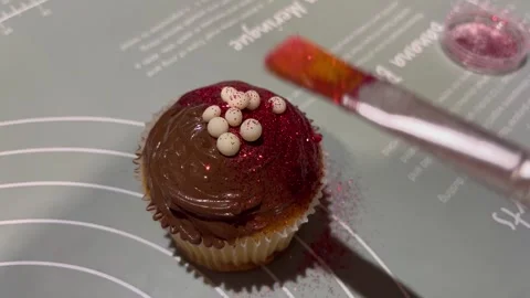 Decorating Chocolate Cupcakes with Red Glitter and Pearl Sprinkles Stock Footage 345306818