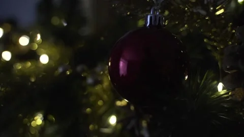 Decorating Christmas tree with balls on the background of bright festive lights Stock Footage 221213285