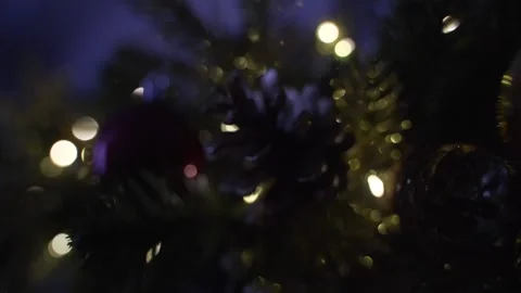Decorating Christmas tree with balls on the background of bright festive lights Stock Footage 221213601