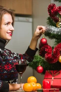 Decorating Christmas tree on bright background with presents Stock Photos