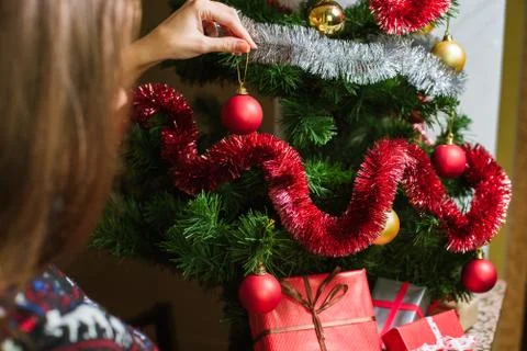 Decorating Christmas tree on bright background with presents Stock Photos