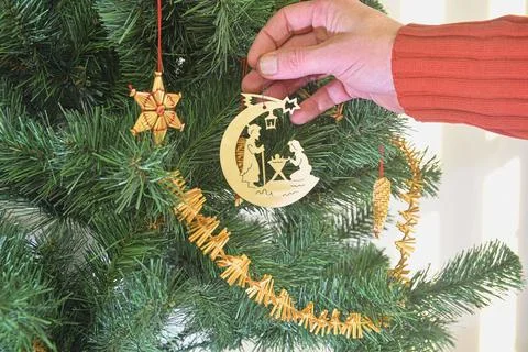 Decorating Christmas tree on bright background. Hand holding a christmas tree Fotos de archivo