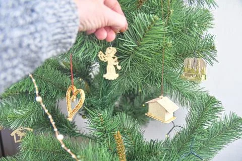 Decorating Christmas tree on bright background. Hand holding a christmas tree Fotos de archivo