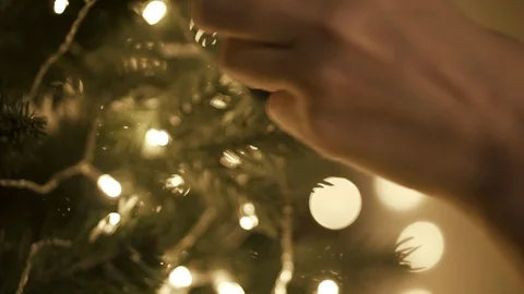 Decorating Christmas tree. Close-up. Christmas lights bokeh background. Warm lig 스톡 동영상 98952895
