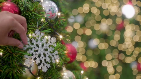 Decorating a Christmas tree. hands decorating christmas tree with red baubles Stock Footage 257292450