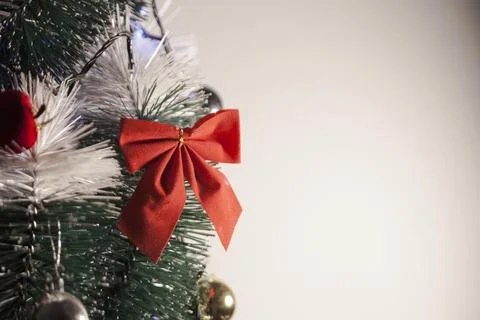Decorating a Christmas tree with a red loop, creating a beautiful and harmoni Фото