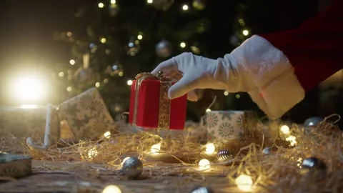 Decorating the Christmas Tree with a Red Present Gift Under the Branches 库存影片 331107083