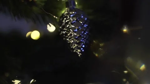 Decorating Christmas tree with silver cone on the background of festive lights Stock Footage 221213745