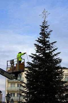Decorating a city Christmas tree using a boom lift to lift workers and plac.. Stock Photos
