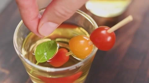 Decorating clear tomato soup with basil. Stock Footage 159400083