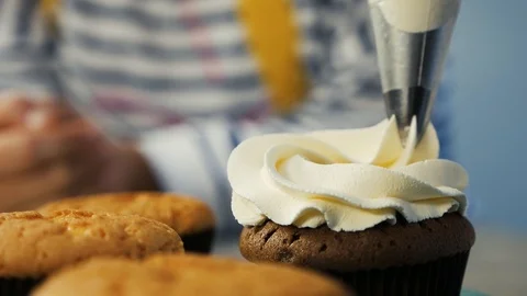 Decorating cup-cake with cream. Confectioner making multicolor cupcakes Stock Footage 103286181