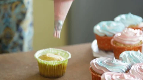 Decorating cup-cake with cream. Using cooking bag, confectioner making Stock Footage 76810168