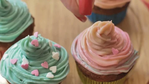 Decorating cup cake with cream using cooking bag confectioner making multicolor Stock Footage 88134667