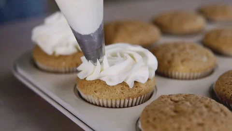 Decorating cupcake with cream. Using cooking bag, confectioner making muffins Video stock 81474490