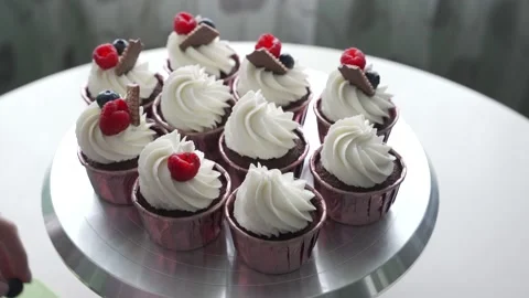 Decorating cupcake with white cream and berries Stock Footage 150673494