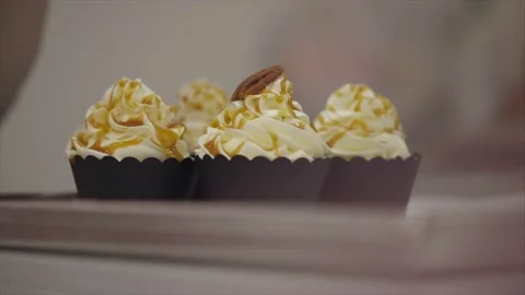 Decorating Cupcake With Whole Nuts In Bakery. Woman Putting Nuts On Muffin Stock Footage 143717547