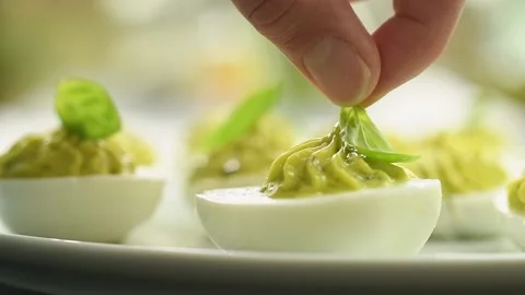 Decorating deviled eggs with basil. 스톡 동영상 165616352