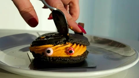 Decorating funny cup-cake with chocolate eyes and red smile. Muffin with Stock Footage 318583538