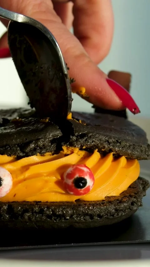 Decorating funny cup-cake with chocolate eyes and red smile. Muffin with Stock Footage 323926228