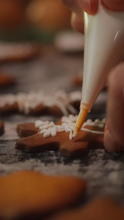 Decorating gingerbread cookies with icing during the holiday season in a coz Stock Footage 331541618