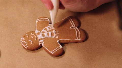 Decorating the gingerbread man with sugar glaze elements. Selective focusing. Stock Footage 167233504