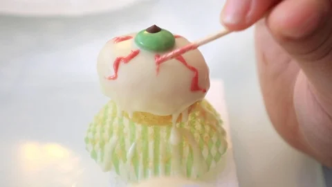 Decorating halloween sweets eye shaped muffin Stock Footage 117072217