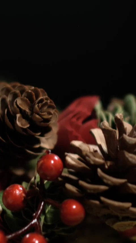 Decorating for holidays with pine cones and red berries in a cozy indoor space Video stock 322790763