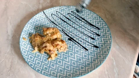 Decorating a meat dish on a plate using sauce. Stock Footage 234808180