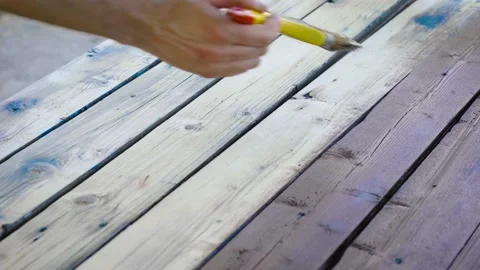 Decorating the old board with brown impregnation. Paint on wood, for protection Stock Footage 130749977