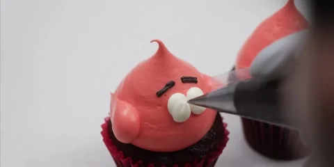 Decorating Patrick Star Cupcake with Piping Bag Close Up Stock Footage 343588812