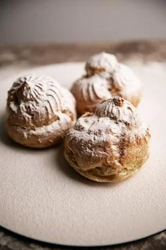 Decorating profiteroles with powdered sugar. Eclair with icing sugar Foto stock