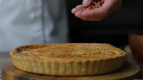 Decorating quiche by sprinkle bacon bits on top. Stock Footage 131548117