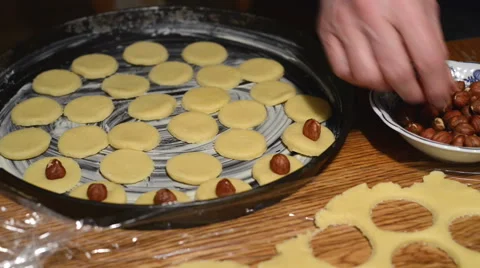 Decorating the raw cookies with hazelnuts. Video stock 45598379