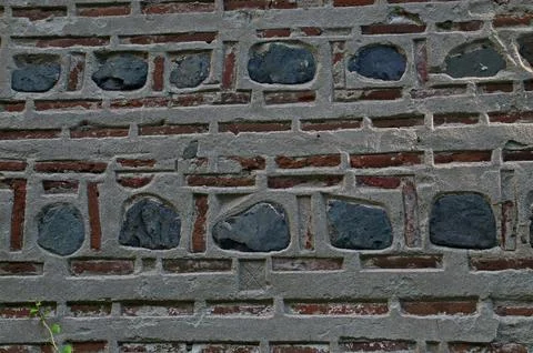 Decorating a red brick wall with stone blocks  attached with concrete Stock Photos