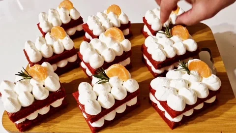 Decorating red velvet cake with orange slices rosemary and edible gold leaf foil Stock Footage 327258870