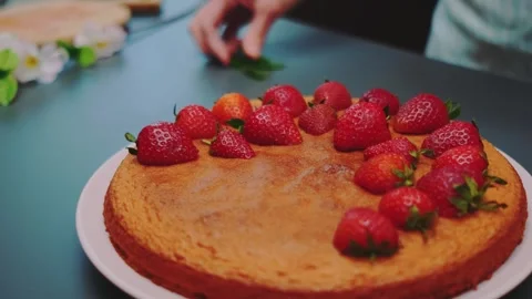 Decorating a round golden-brown cake with fresh strawberries indoors Stock Footage 342866715