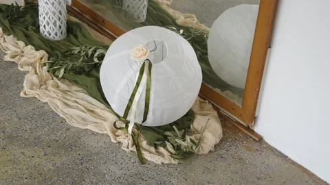 Decorating a space with a paper lantern and natural elements for a simple event Stock Footage 334975892