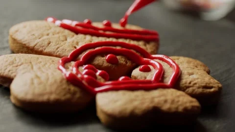 Decorating Stacked Heart Shaped Gingerbread Cookies with Icing Stock Footage 329275912