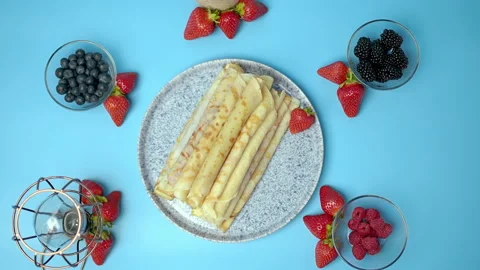 Decorating with summer berries a plate full of french crepes/pancakes. Stock Footage 133606466